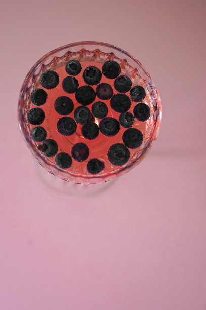 清新而充满活力的粉红色鸡尾酒，在粉红色的背景上点缀着多汁的蓝莓图片下载