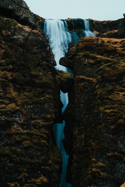 冰岛悬崖环绕的Gljufrabui瀑布的垂直照片图片下载