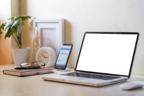 笔记本电脑和智能手机，白色桌子上的空白屏幕。图片下载