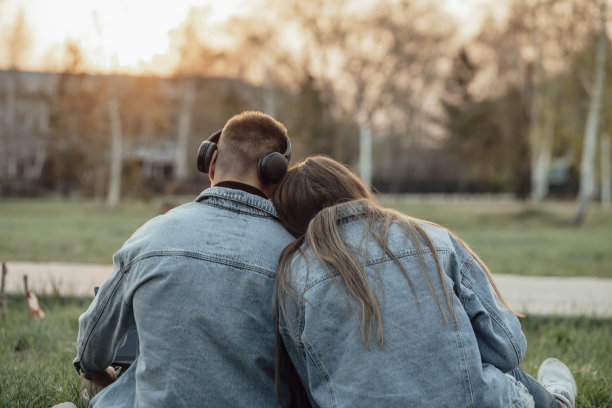 愉快的白人放松学生盘腿坐在打开的笔记本电脑旁，试图在公园里休息一下。图片下载