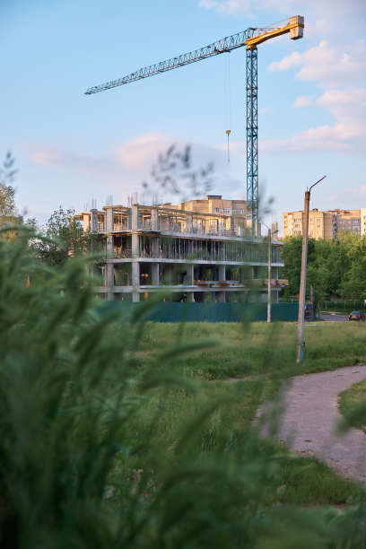 建筑起重机对着天空。建筑工地。垂直的照片。日落。图片下载
