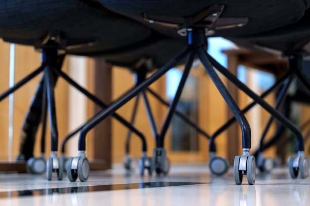 低角度的视角捕捉到了办公椅的坚固和高质量的金属滚轮图片下载