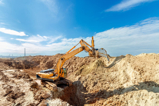 两台挖掘机正在工地挖土，背景是天空，白云飘飘图片下载