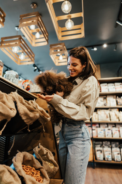 宠物店里有个带着贵宾犬的年轻女人图片下载