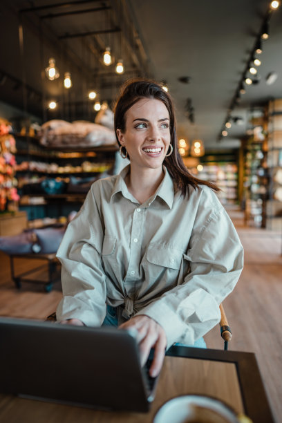 年轻女子坐在自己的宠物店咖啡吧里图片下载