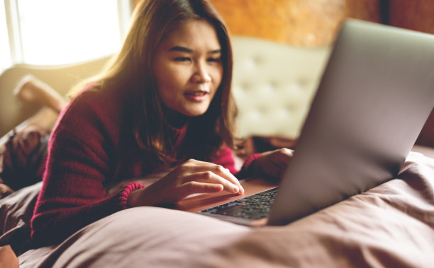 在笔记本电脑上工作的年轻女性图片下载