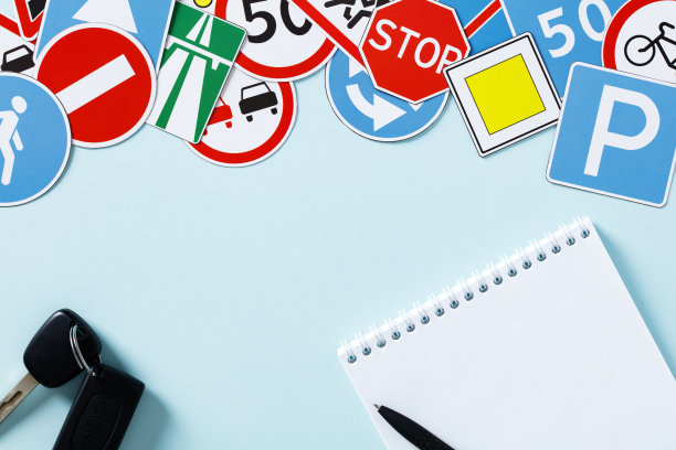 空白记事本，车钥匙，蓝色背景的路标。驾校课程概念。图片下载