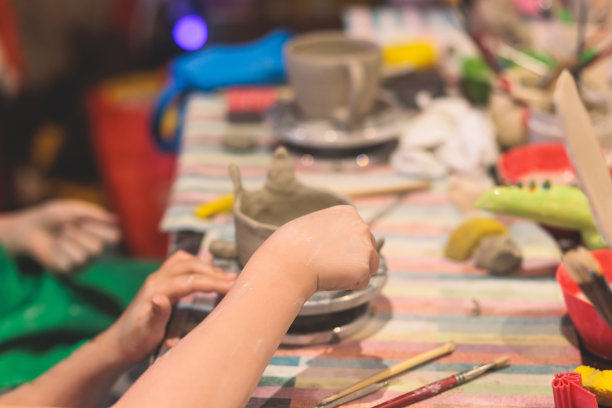 陶艺课幼儿大师班，在陶轮上制作陶罐的过程，陶工湿手制作陶艺手工艺品，陶艺家制作罐子或花瓶图片下载