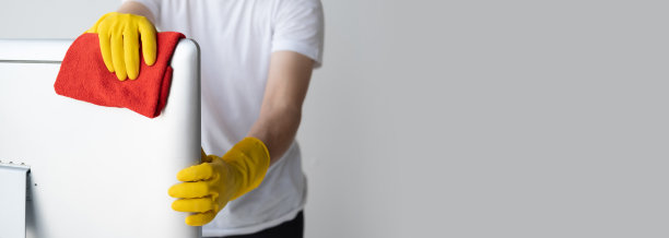 一个人用衣服清洗桌面电脑的特写。清洁办公桌概念。图片下载