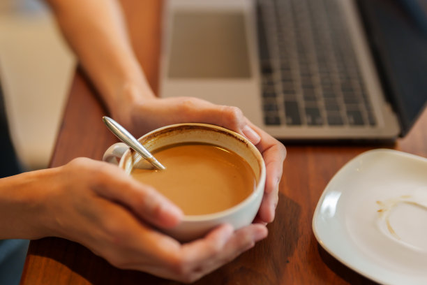 亚洲妇女双手端着一杯咖啡的手特写。有一个杯子，里面装满了即食咖啡。那个女人的手指在摆动。表达紧张的想法图片下载