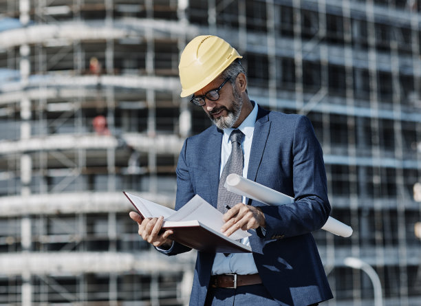 老年商人建筑师头盔施工现场建筑建筑平板电脑防护工作服蓝图方案图片下载