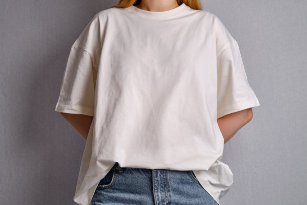 身穿白色t恤的女子在白墙旁摆姿势。手势和情绪。摄影工作室。情感，力量和乐趣的概念。休闲服。铭文和标志的空间图片下载