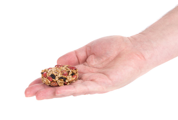 用烤花生和葵花籽做成的饼干放在手掌上。图片下载