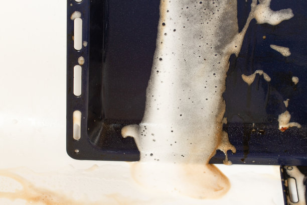 用泡沫清洁剂清洗烤箱。高质量照片图片下载