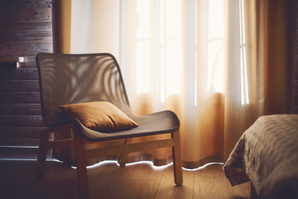 舒适的现代住宅内部带有民族波西米亚风格的装饰。木制地板上有靠垫的扶手椅图片下载