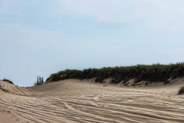 海滩上的车辆已经行驶到地平线上的道路与海滩草-文字空间-大天空图片下载