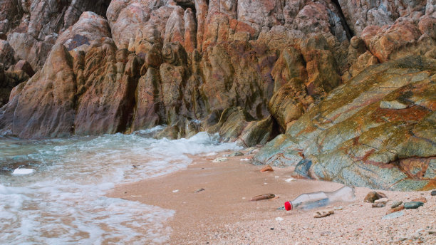 悲伤的海滩。海滩上到处都是塑料垃圾，将我们的星球带入下一波致命的变化。海滩上美丽雄伟的悬崖景色被塑料垃圾破坏了。海滩上的垃圾图片下载