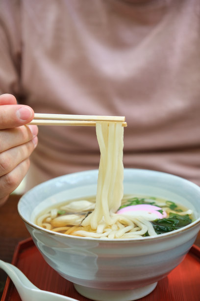 在日本广岛宫岛，欧洲游客正在吃传统的牡蛎乌冬面。图片下载