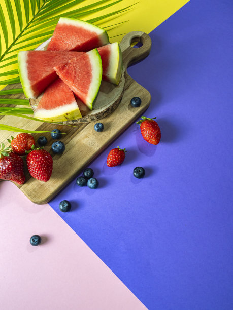 夏天的概念。垂直照片的新鲜西瓜，红色的水果在三色背景。图片下载