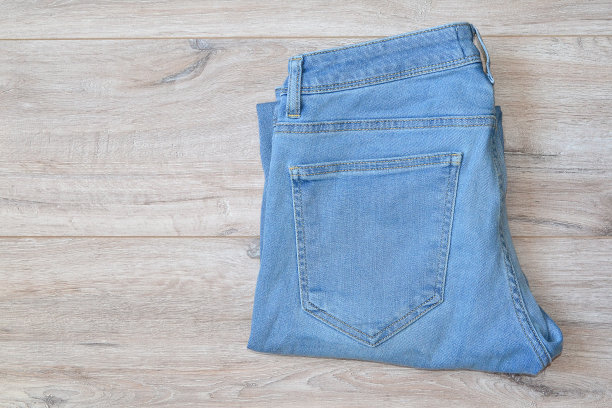 浅蓝色的男士牛仔裤叠着放在桌子上图片下载