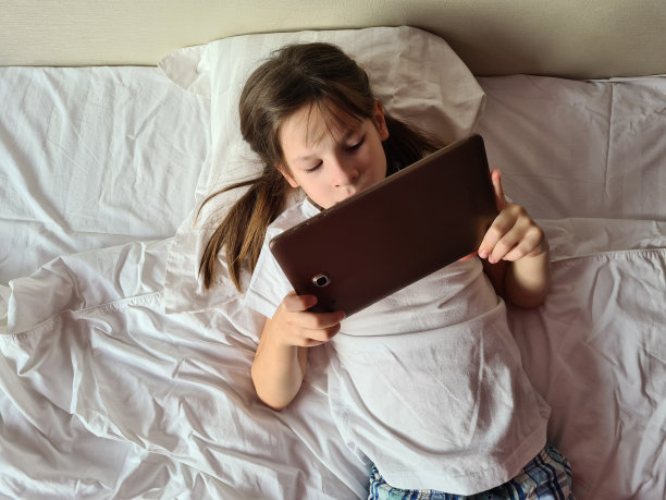 认真细心的白人女孩用平板电脑看视频和卡通图片下载