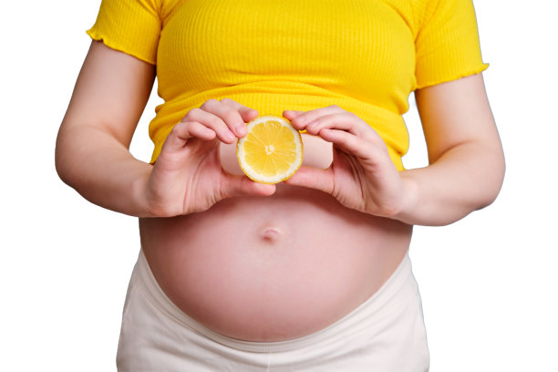 一个孕妇手里的半个柠檬，被隔离在白色的背景上图片下载
