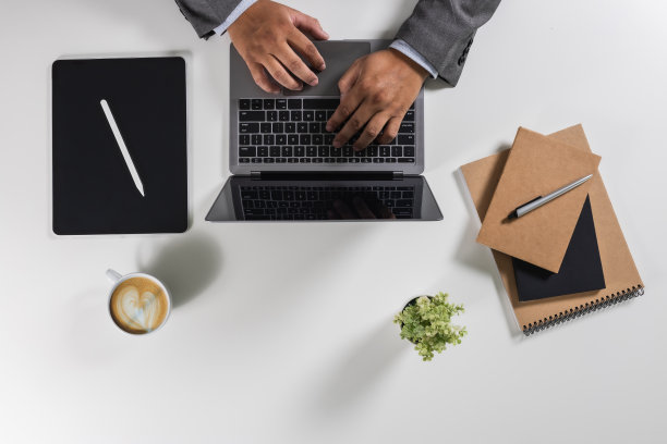 人设计师电脑笔记本电脑资料文件研究图表金融市场在办公室的一张白色的桌子上工作工作场所俯视现代空间平铺图片下载