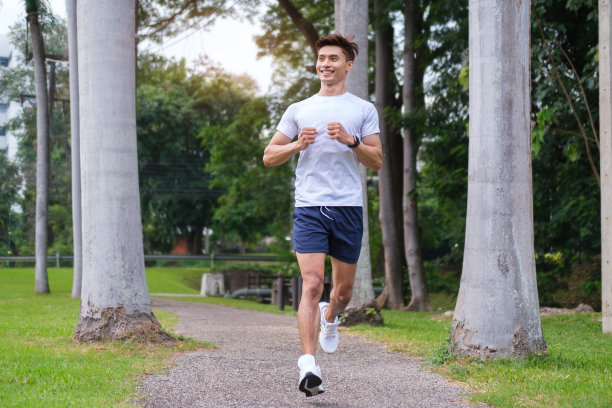 穿着运动服在公园慢跑的男子全身照片。图片下载