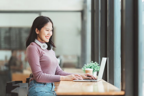 年轻女子在咖啡馆使用笔记本电脑的照片，商务人士在咖啡店使用笔记本电脑的照片图片下载