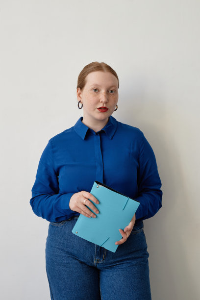 年轻的红发女子穿着亮蓝色的商务休闲装图片下载