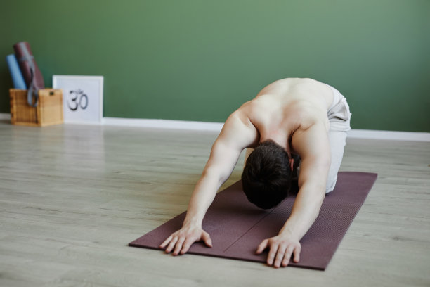光着膀子的年轻人在做瑜伽，做巴拉体式放松图片下载