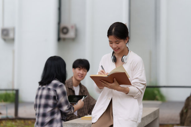 美丽年轻的亚洲女大学生与朋友在户外。在大学校园工作的大学生。图片下载
