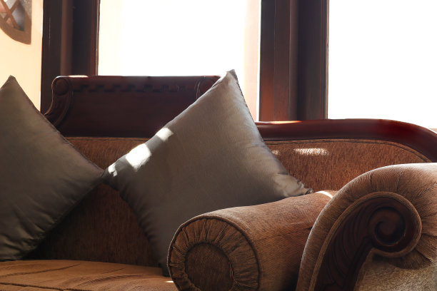 客厅休闲沙发上的枕头特写。酒店房间靠窗的舒适沙发。图片下载