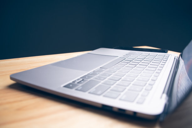 侧视图笔记本电脑，空白屏幕，放在办公室的木桌上，没有人。办公空间与电脑，技术，互联网，工作，回到学校，网上购物的概念。左侧拷贝空间。图片下载