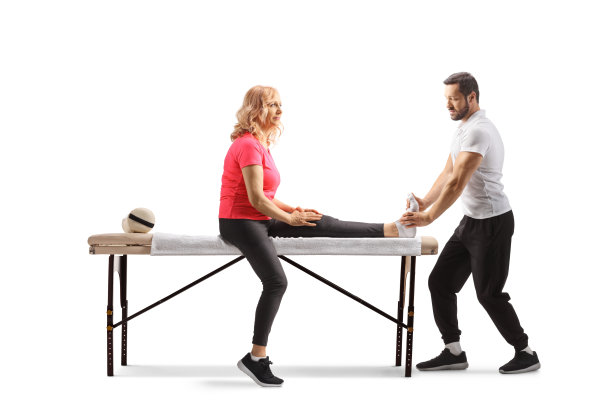 理疗师正在治疗一位腿部受伤的成熟女性图片下载