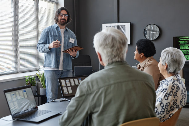 面带微笑的大胡子男子在给老年人上IT电脑课图片下载