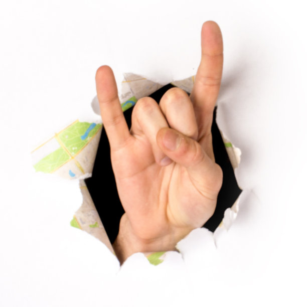 一只手从纸洞里伸出来的特写，一个摇滚标志，孤立的图片下载