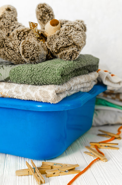 一堆要洗的衣服和一只泰迪熊图片下载