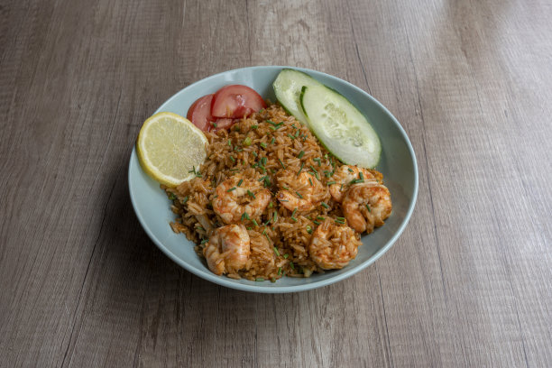 巴黎，法国- 06 2023:亚洲菜肴烹饪静物。在米饭里撒上虾、西红柿、黄瓜和柠檬图片下载