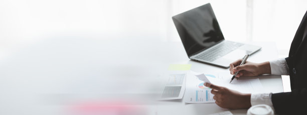 一位女财务人员正在审阅公司的财务文件，从财务部门发来的月度财务报表摘要。管理公司财务以实现准确性和增长的理念。图片下载