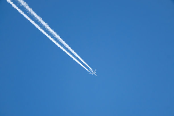 白色的尾迹划过清澈的蓝天图片下载