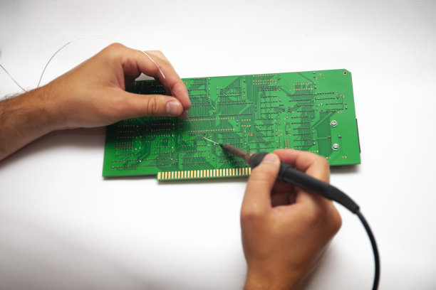 人的手在用烙铁焊接PCB上的元件。DIY概念。图片下载