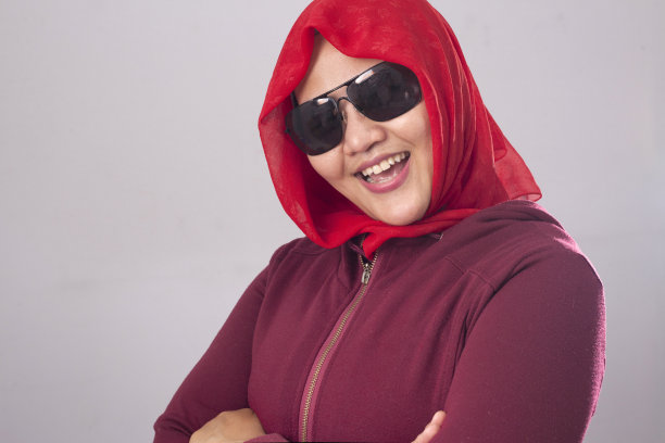 自信的穆斯林女士穿红衣，双臂交叉图片下载