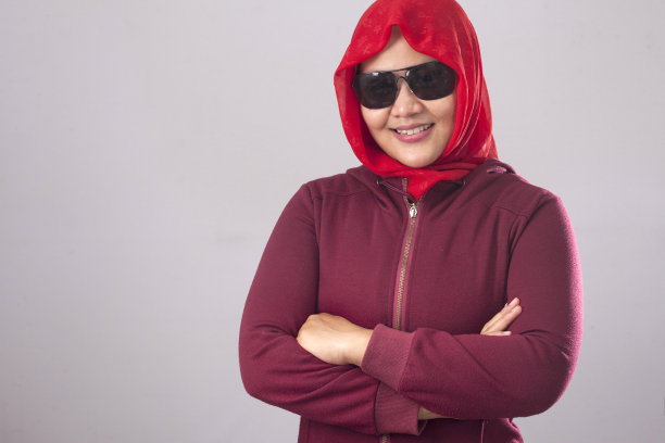 自信的穆斯林女士穿红衣，双臂交叉图片下载