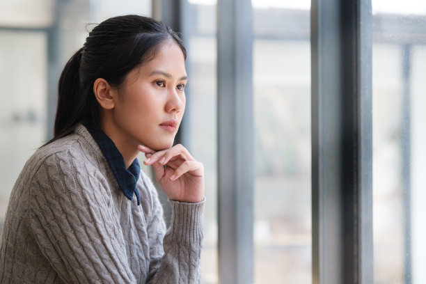 沉思的女商人坐在办公室里，若有所思地望着别处，梦想着，计划着未来。图片下载