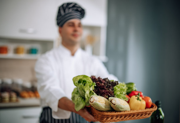 专业的厨艺大师以极大的激情和热情准备了一碗各式各样的果蔬沙拉。熟练地混合所有的成分和材料，小心和精确。图片下载