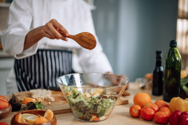专业的厨艺大师以极大的激情和热情准备了一碗各式各样的果蔬沙拉。熟练地混合所有的成分和材料，小心和精确。图片下载