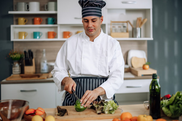 专业的厨艺大师以极大的激情和热情准备了一碗各式各样的果蔬沙拉。熟练地混合所有的成分和材料，小心和精确。图片下载