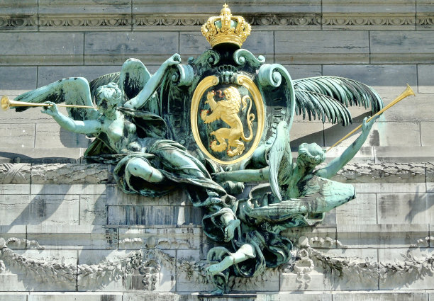 在比利时布鲁塞尔的五十周年纪念公园，两个带翅膀的青铜天使在装饰五十周年纪念拱廊的比利时金色盾形纹章下吹着金色的号角。图片下载