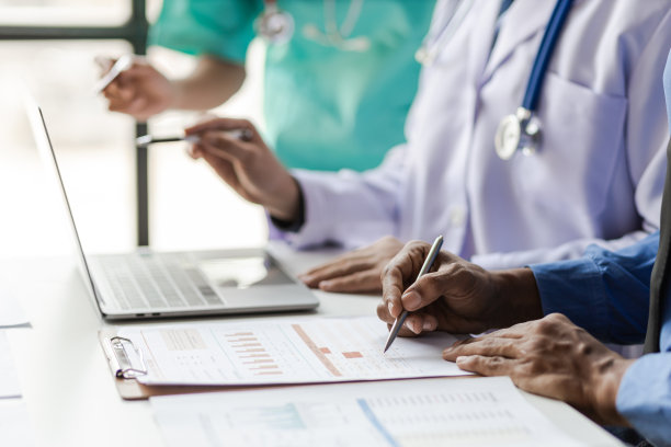 团队，医疗分析师和医生在医院会议室咨询图形，数据和图表的文书工作。医护人员讨论统计数据、研究结果和创新。图片下载
